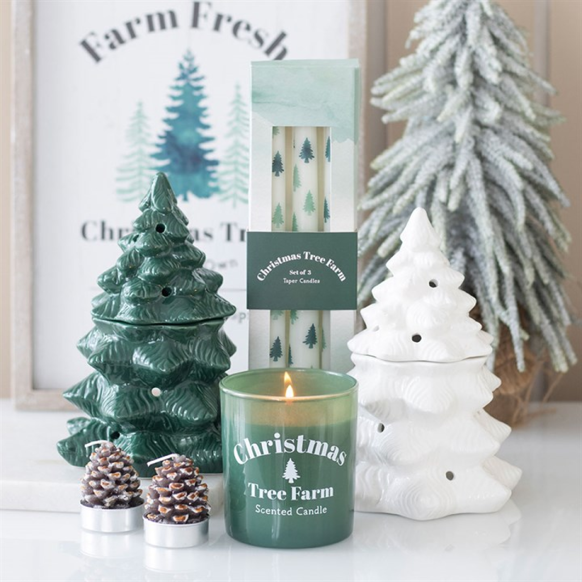 Decorative Christmas-themed candles and packaging on a table with a 'Farm Fresh' sign in the background.