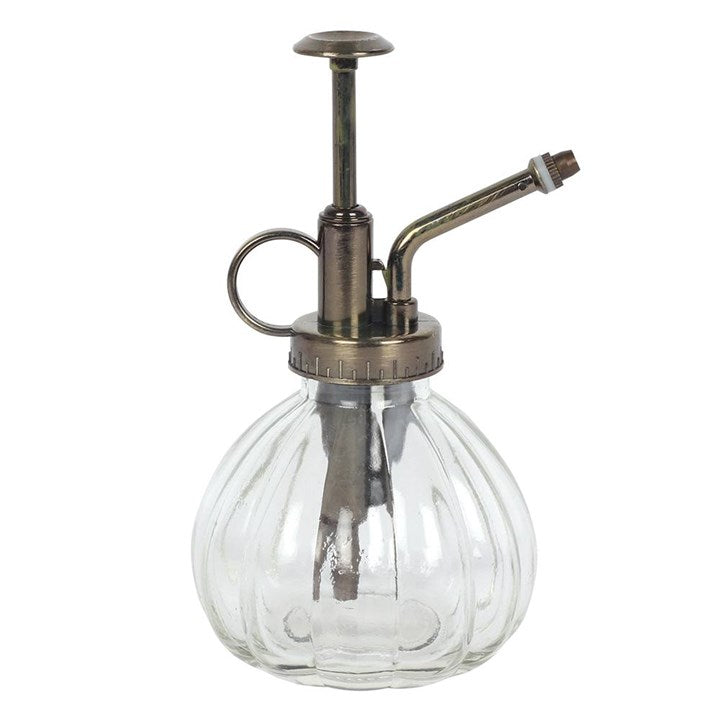 Clear glass spray bottle with bronze metal nozzle on a white background