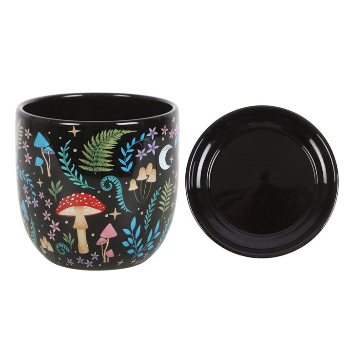 Black mug with colorful forest design on a white background