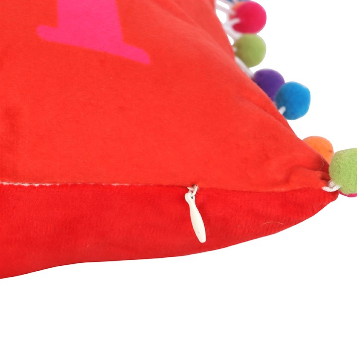 Red pillow with colorful pom-poms on a white background
