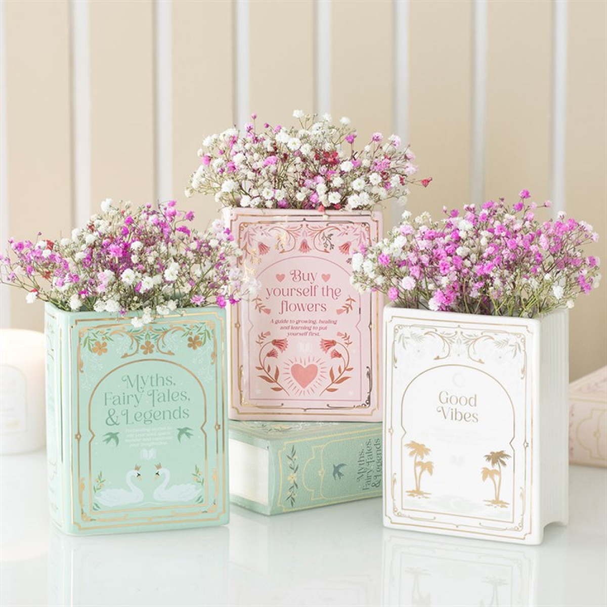 Decorative book planters with flowers on a light background