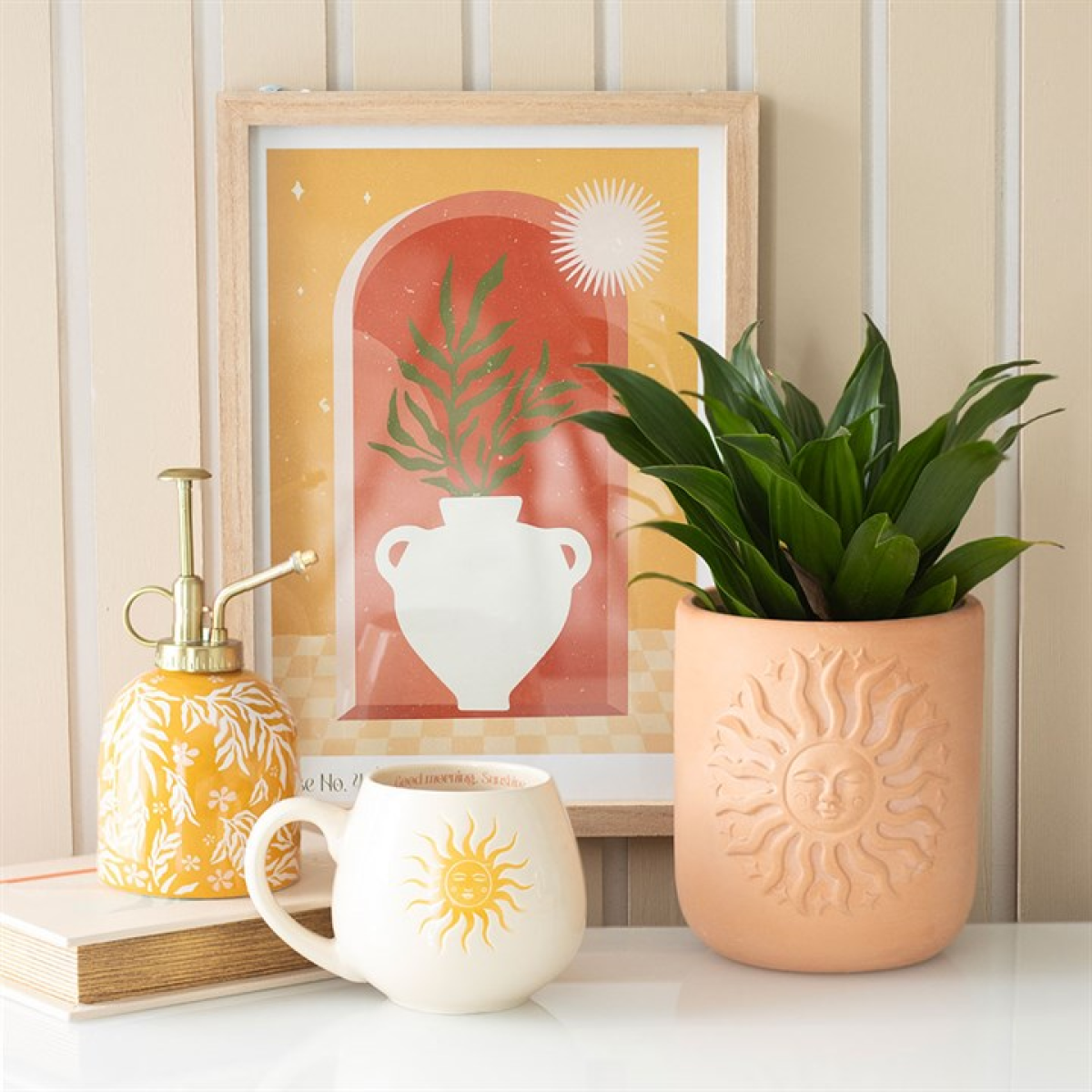 Decorative items including a plant, mug, and framed artwork on a shelf.