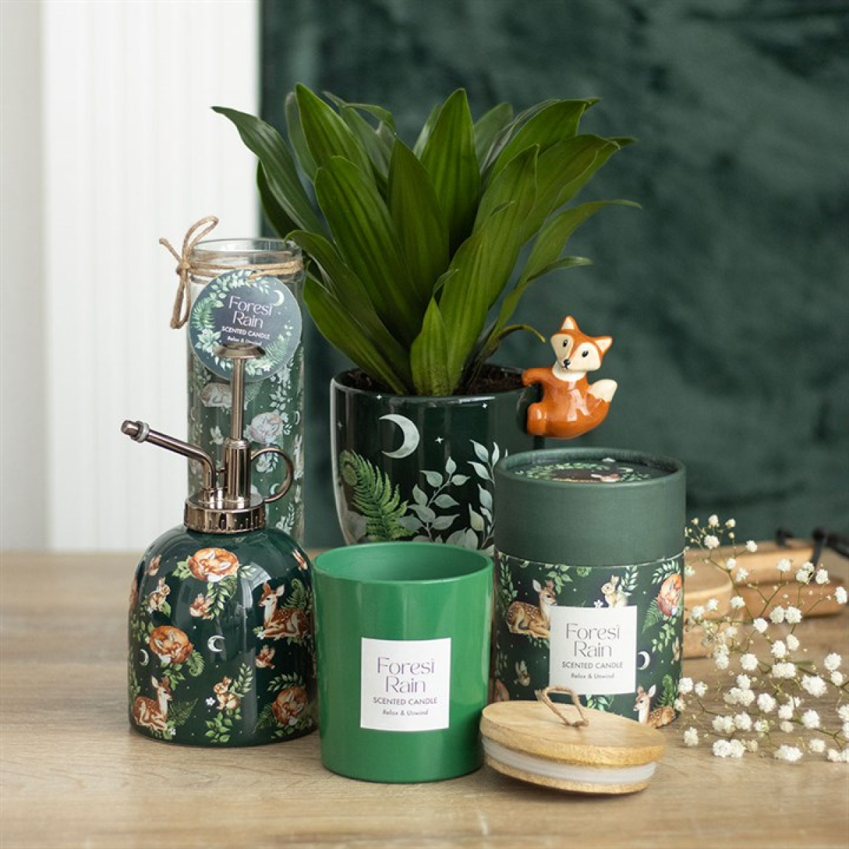 Decorative items including a plant, candle, and soap dispenser with 'Forest Rain' branding on a wooden surface.