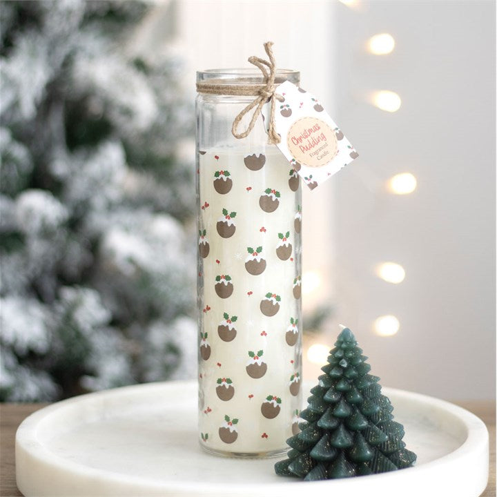 Decorative candle with a pattern in a glass jar, surrounded by Christmas decorations.
