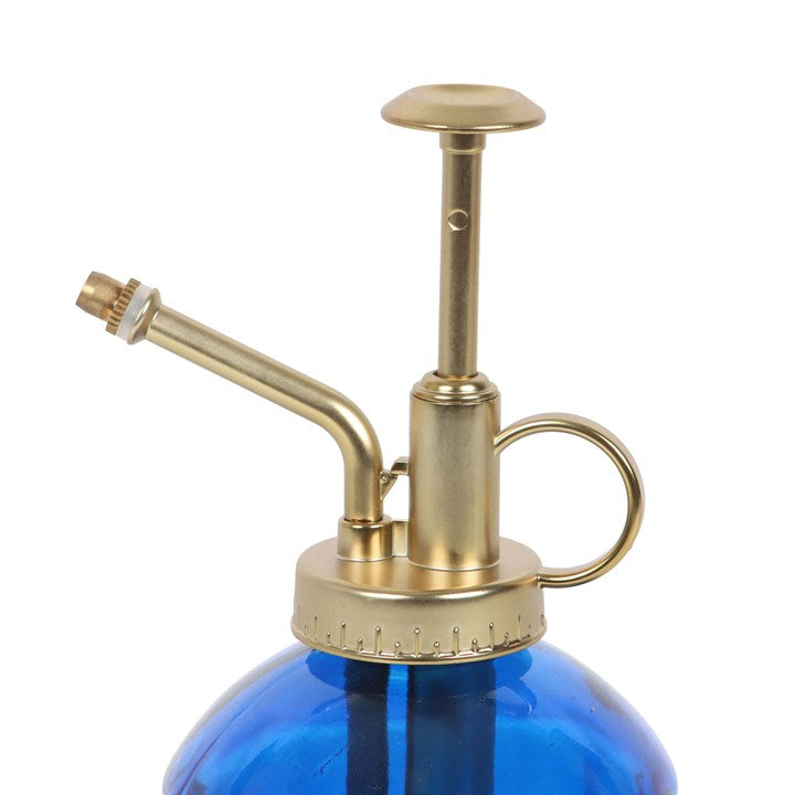 Blue glass spray bottle with brass nozzle and pump on a white background