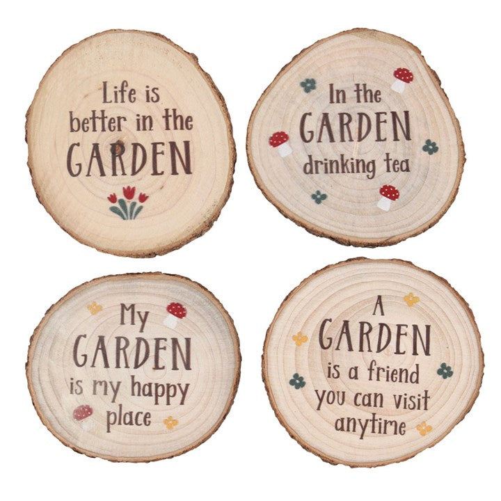 Four wooden coasters with garden-themed sayings on a white background