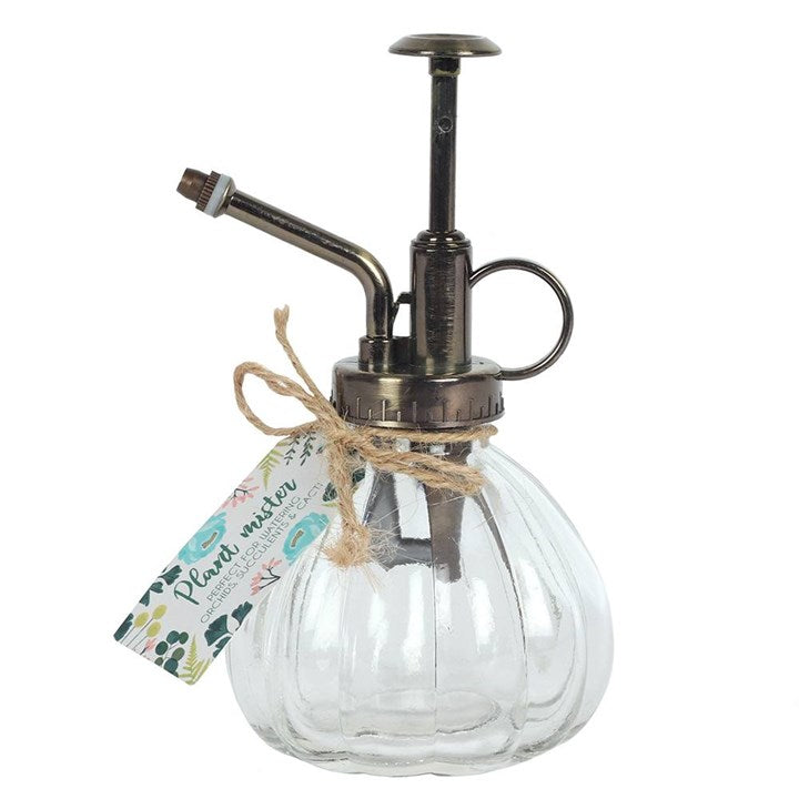 Clear glass spray bottle with metal nozzle on a white background