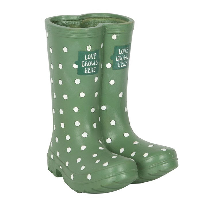 Green rain boots with white polka dots and 'Love Grows Here' text on a white background
