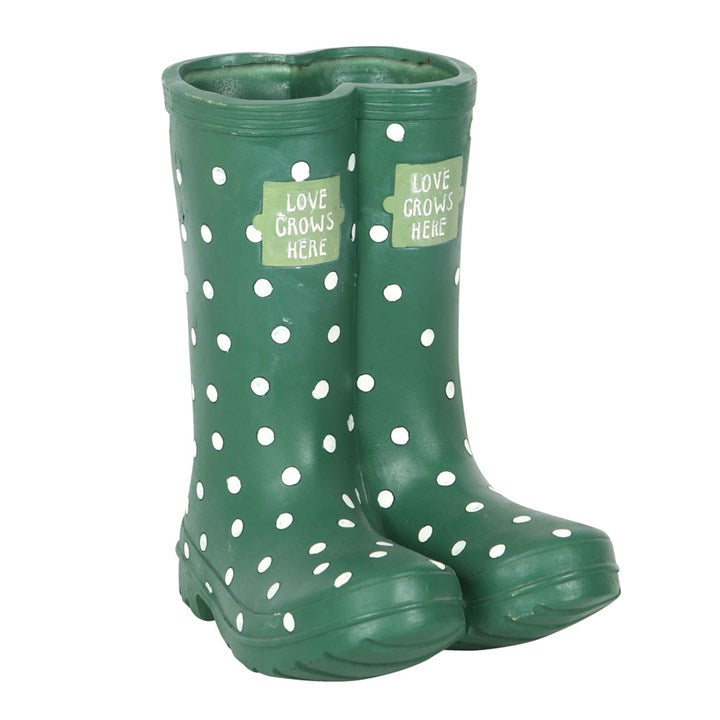Green polka dot rain boots with 'Love Grows Here' labels on a white background