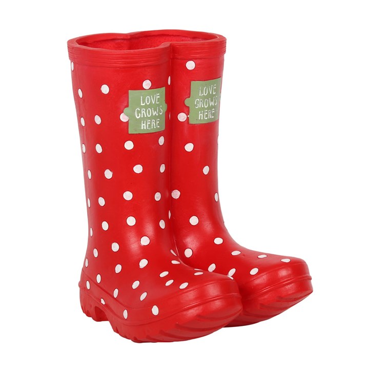 Red polka dot rain boots with 'Love Grows Here' labels on a white background