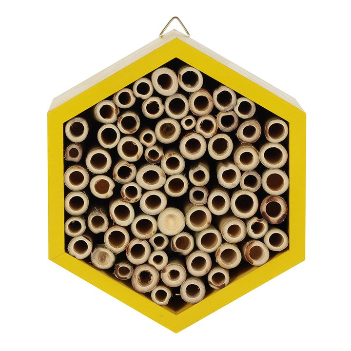 Hexagonal bee hotel with wooden tubes on a white background