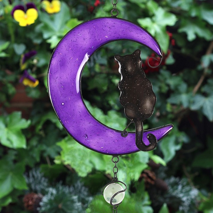 Decorative purple crescent moon with a cat on a green leafy background