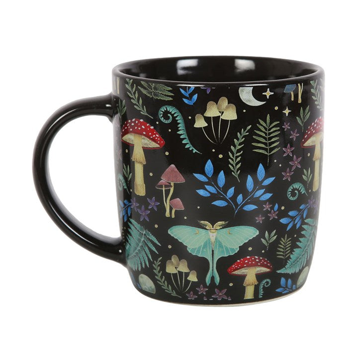 Black mug with colorful forest-themed design featuring mushrooms and a butterfly on a white background