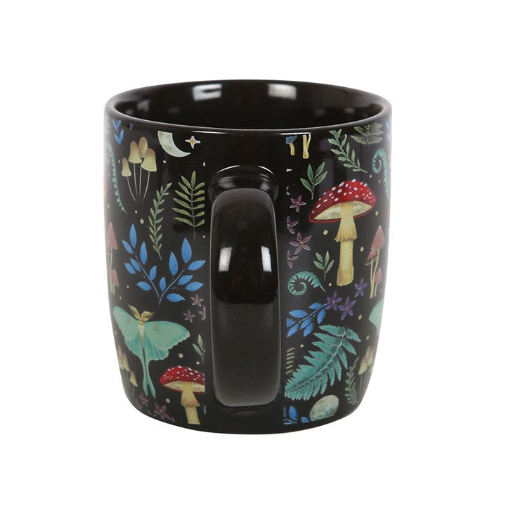 Black mug with a colorful forest pattern on a white background