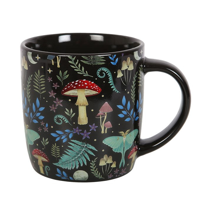 Black mug with colorful forest-themed design featuring mushrooms and fairies on a white background