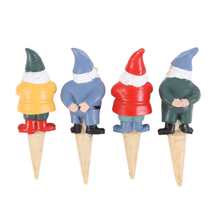 Four miniature garden gnome figurines on wooden stakes with colorful outfits.