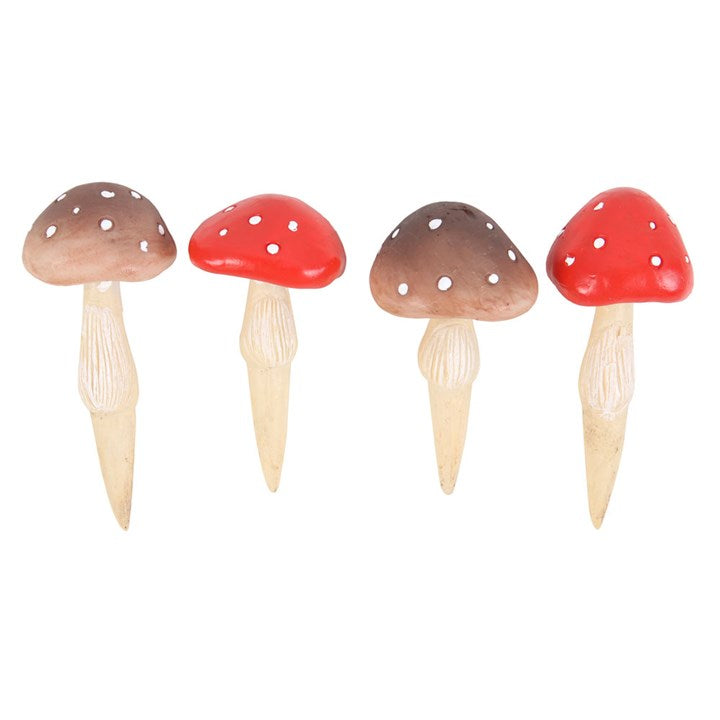 Four wooden mushroom decorations with red and brown caps on a white background