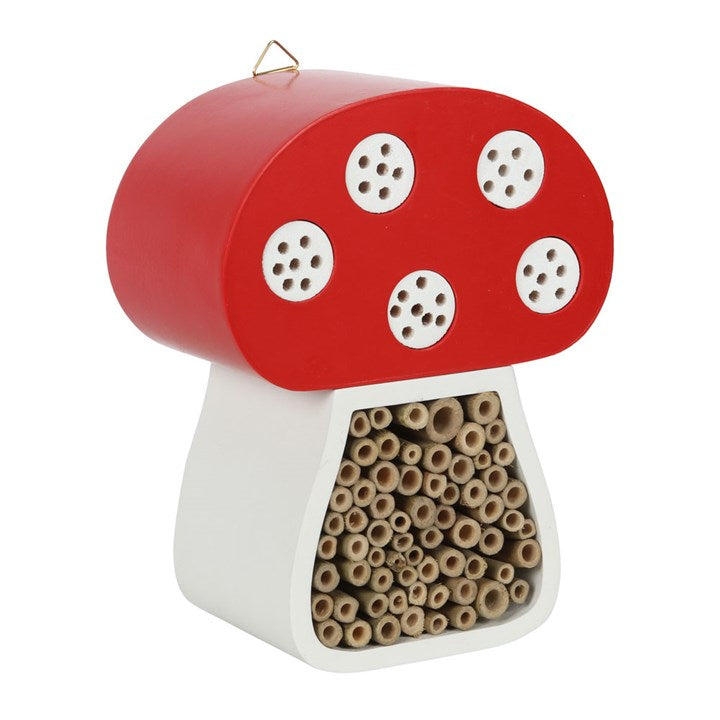 Mushroom-shaped insect hotel with red top and white base on a white background