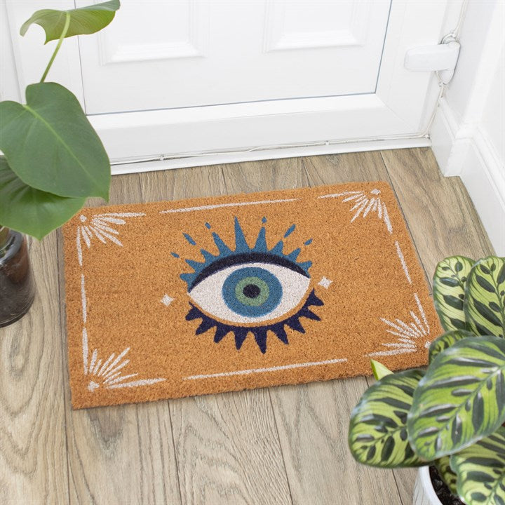 Decorative doormat with eye design on a wooden floor