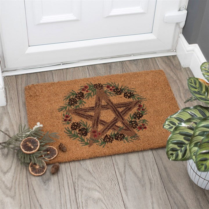 Decorative doormat with a star and wreath design on a wooden floor.