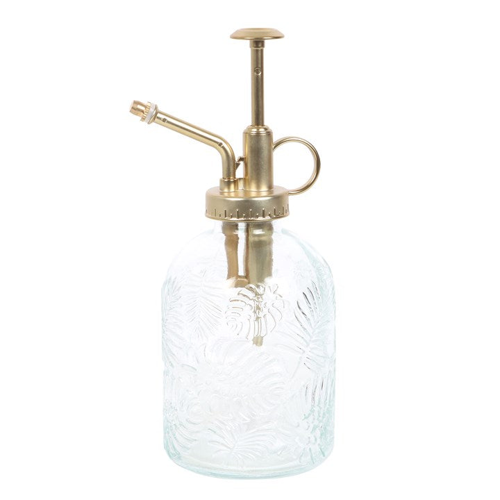 Clear glass spray bottle with brass nozzle on a white background
