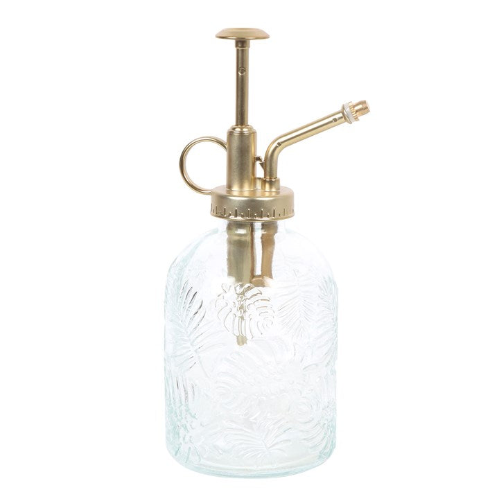 Clear glass spray bottle with brass pump on a white background