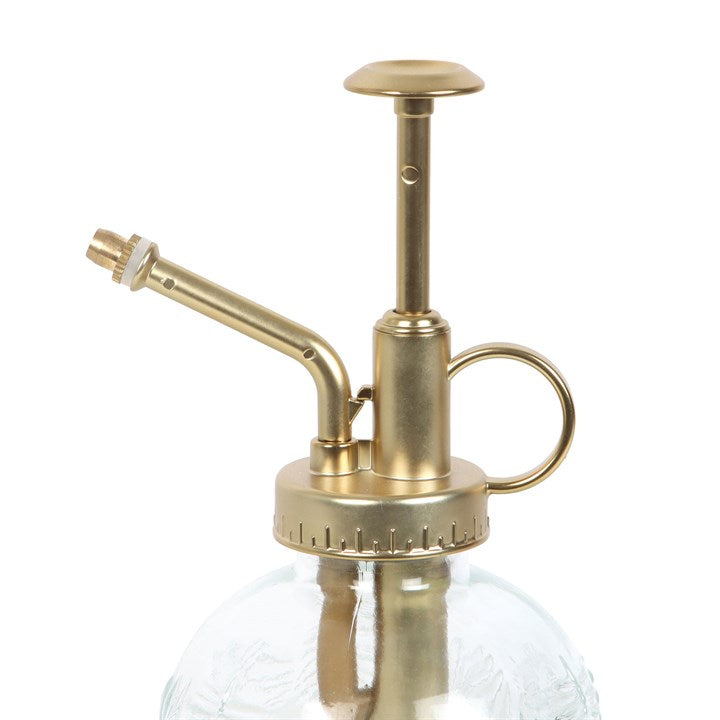 Brass and glass spray bottle on a white background