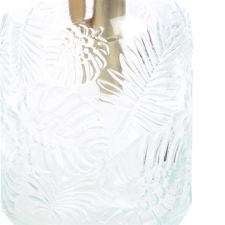 Clear glass vase with leaf pattern on a white background