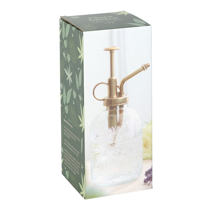 Glass spray bottle with brass nozzle in packaging on a white background