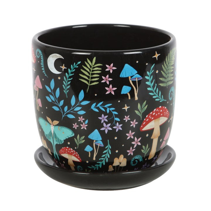 Black ceramic pot with colorful forest-themed design on a white background