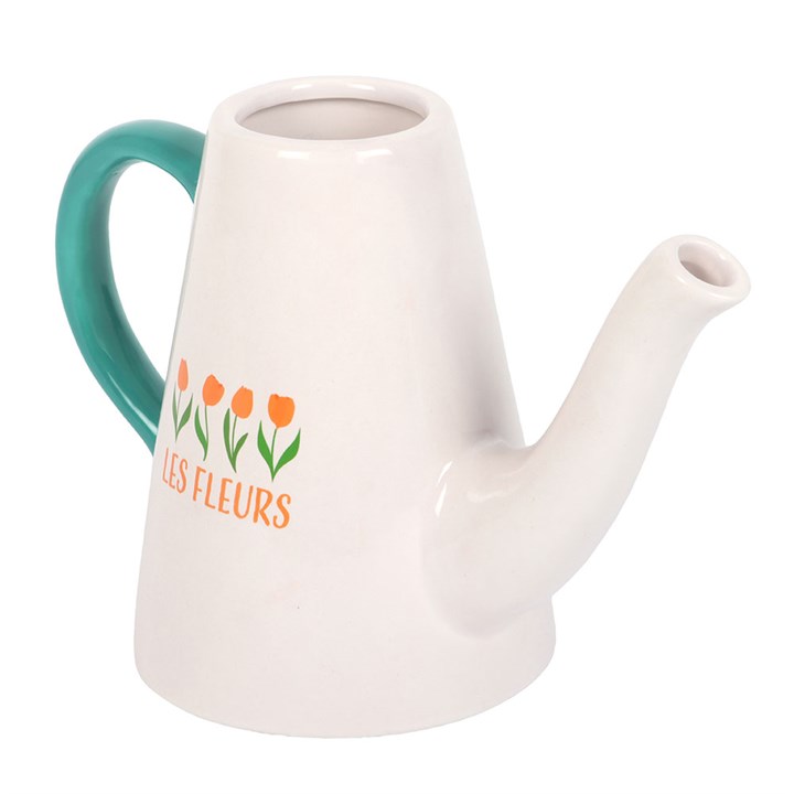 White ceramic watering can with teal handle and floral design on a white background