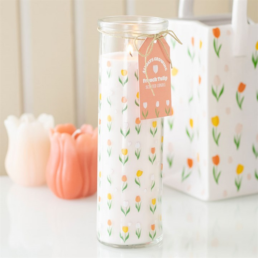 Candle with floral design and tag on a white surface