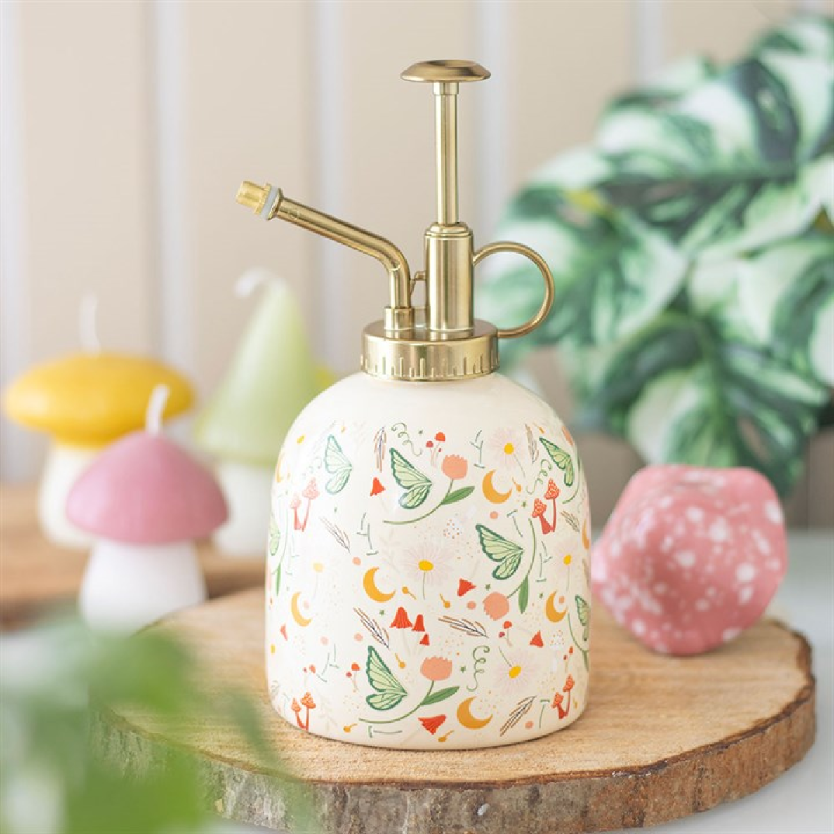 Decorative plant spray bottle with floral design on a wooden surface