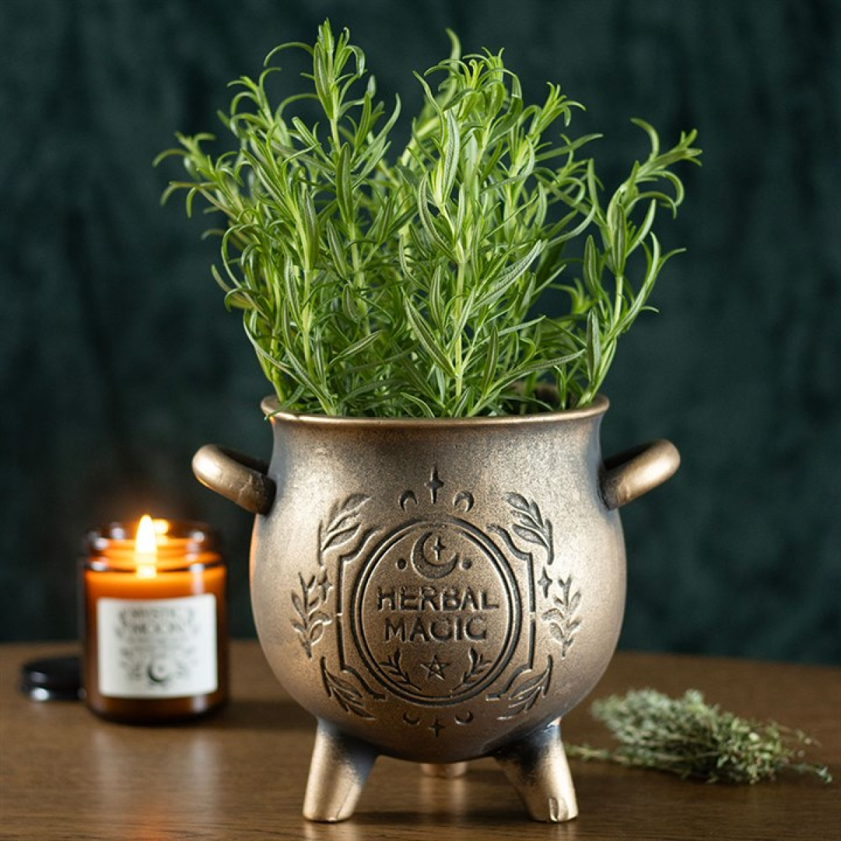 Decorative pot with a plant labeled 'Herbal Magic' on a wooden surface with a candle in the background.