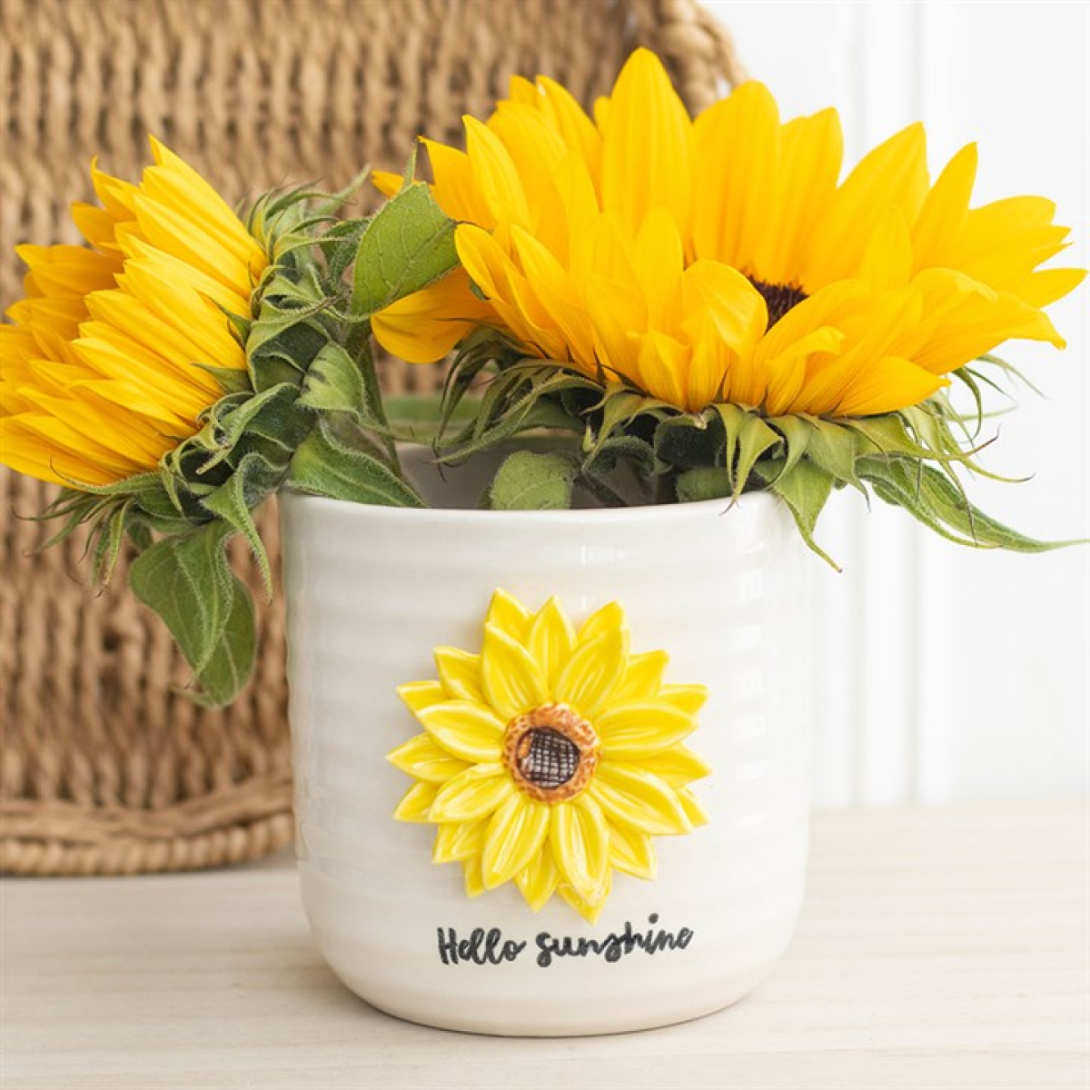 White mug with sunflower design and 'Hello Sunshine' text, filled with sunflowers.