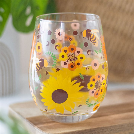 Clear glass with sunflower and bee design on a wooden surface