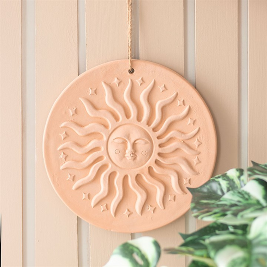Decorative sun wall hanging on a wooden panel background